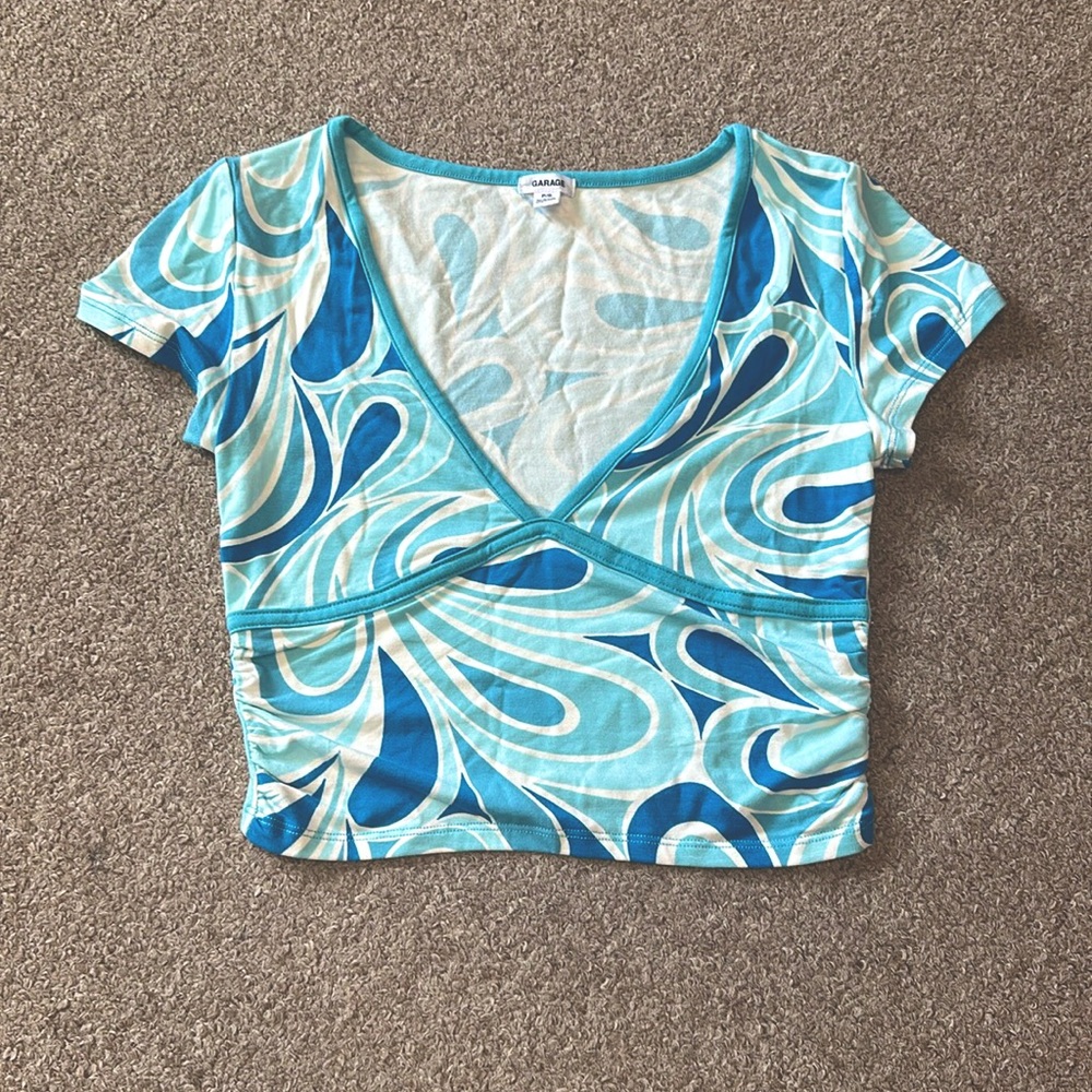 Cute pattern fits snug & cropped. Good cond. V-neck rayon and spandex blend.